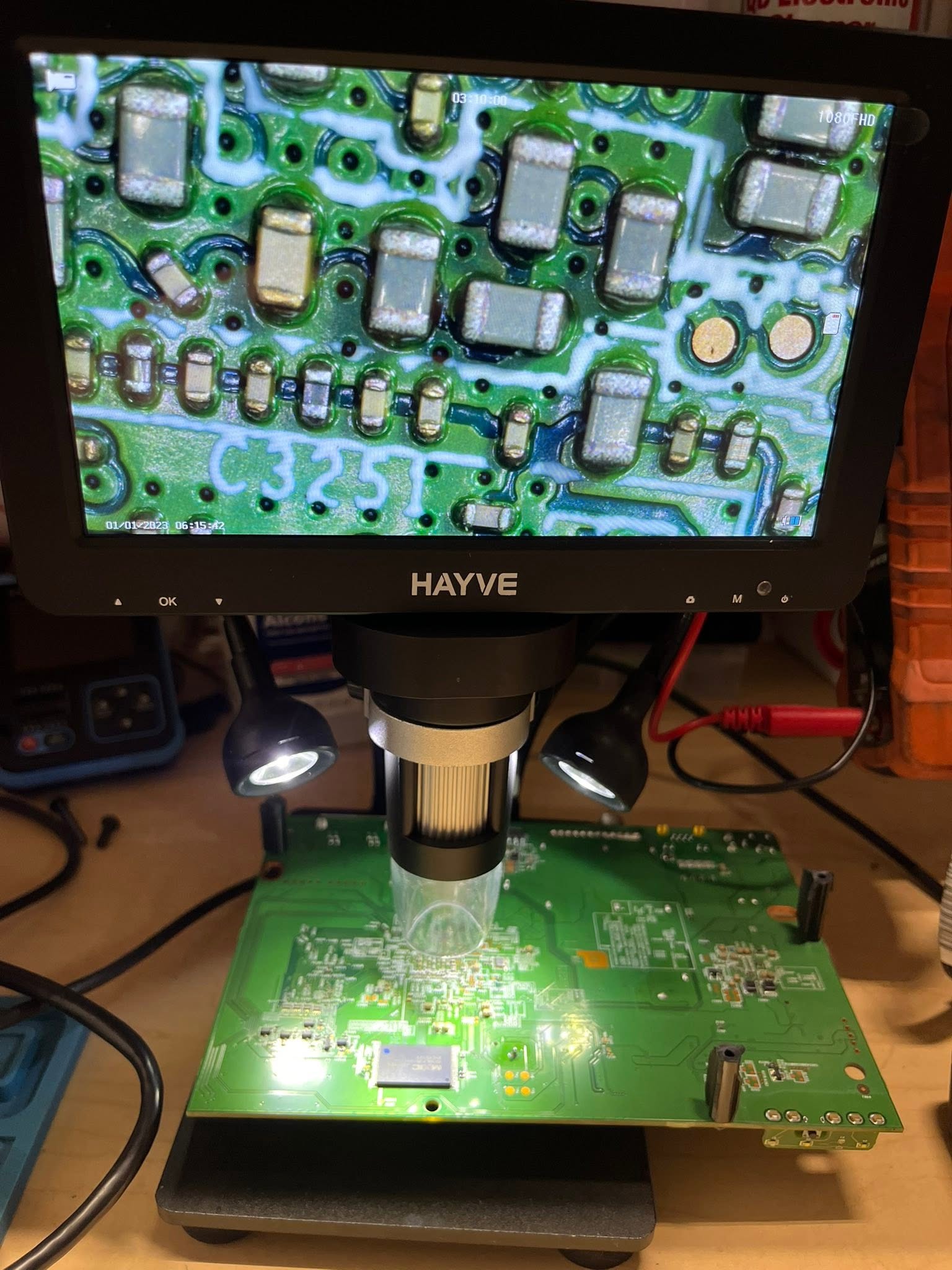 HAYVE digital microscope over a green control-board PCB